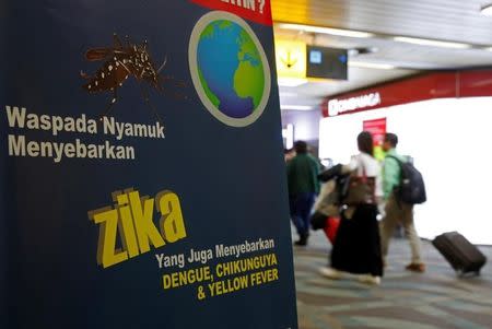 Airline passengers walk past a banner about the Zika virus shortly after landing from Singapore at Soekarno-Hatta airport in Jakarta, Indonesia August 30, 2016. The banner reads "Careful mosquitos spread Zika." REUTERS/Beawiharta