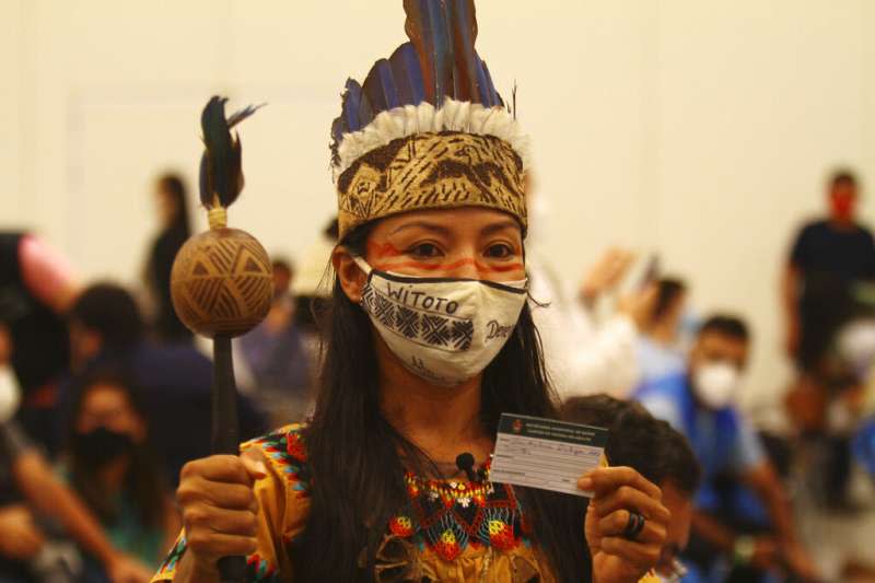 新冠病毒在巴西亞馬遜州首府瑪瑙斯（Manaus）嚴重肆虐，當地一位女性穿著原住民服飾接種新冠疫苗後，拿到接種疫苗證明書。（美聯社）