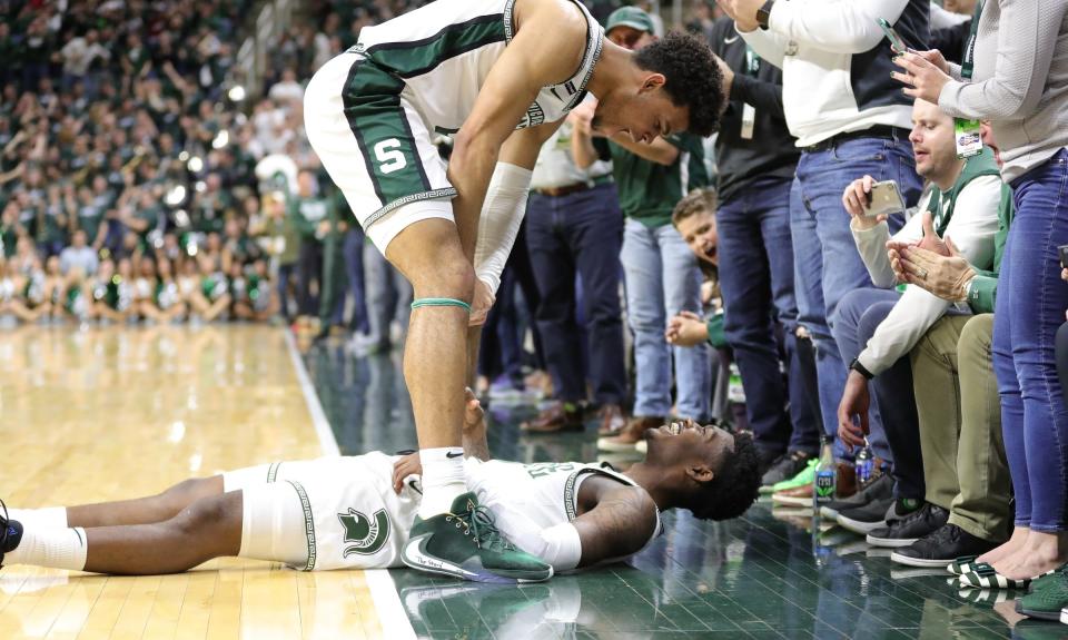 Michigan State's Rocket Watts lays on the ground in celebration with Malik Hall, after hitting a 3 during the 80-69 win against Ohio State on Sunday, March 8, 2020 at the Breslin Center.