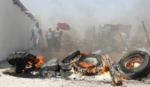 Tires burn in the Sondela informal settlement next to the Anglo American Platinum mine in northwestern Rustenburg after residents blocked roads to keep the police out. South African police clashed with residents near an Anglo American mine on Thursday, as miners at nearby Lonmin went back to work