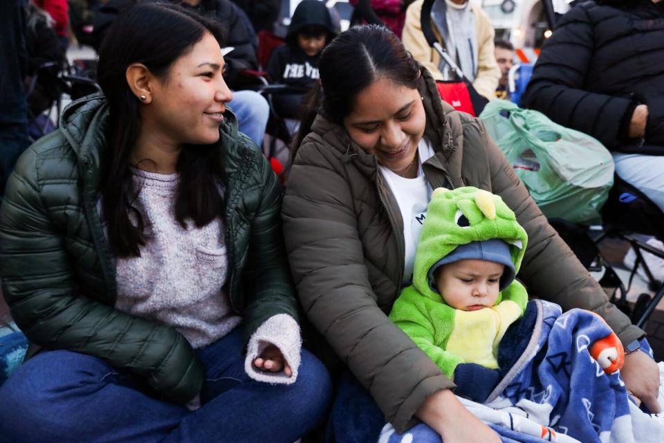 Two women and a child wait for the start of the 135th Rose Parade