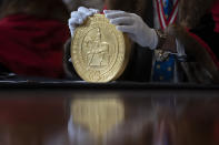 A 15-kilogram (33-pound) gold coin produced to celebrate the late Queen Elizabeth II's Platinum Jubilee, is assessed during the "Trial of the Pyx,'' a ceremony that dates to the 12th Century in which coins are weighed in order to make certain they are up to standard, at the Goldsmiths' Hall in London, Tuesday, Feb. 7, 2023. A jury sat solemnly in a gilded hall in central London on Tuesday, presided over by a bewigged representative of the crown in flowing black robes, but there were no criminals in the dock. (AP Photo/Kin Cheung)