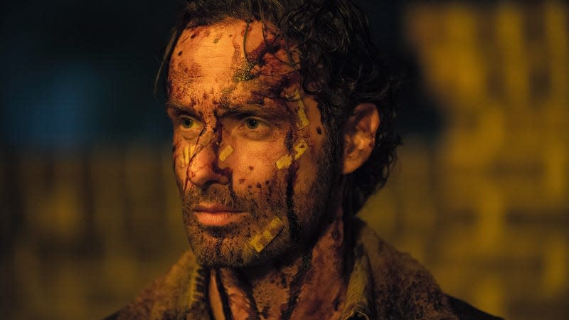 A bloodied, bandaged Rick Grimes stares ahead, dead-eyed.