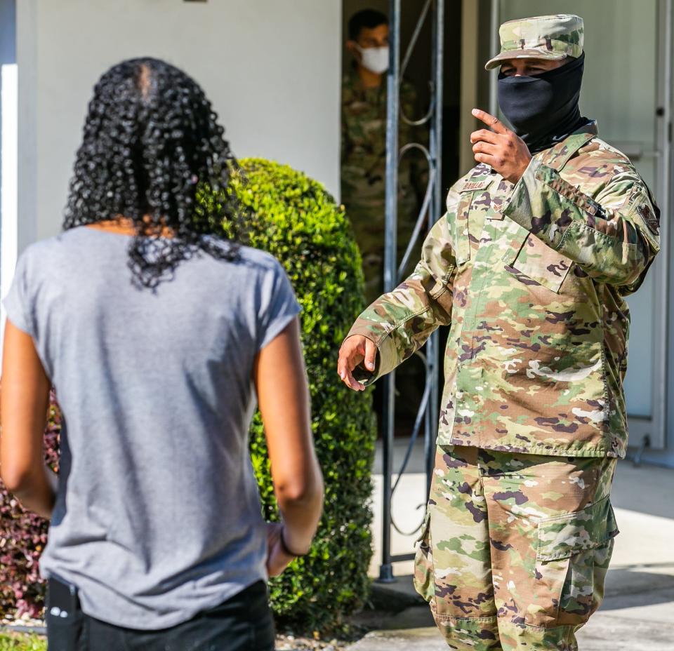 An Air National Guardsman directs people where to fill out paper work to receive a COVID vaccination in Ocala this April. [Doug Engle/Ocala Star Banner]