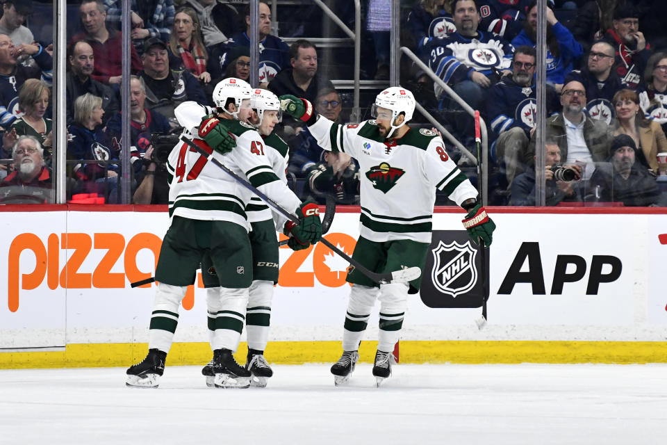 Minnesota Wild's Marco Rossi, center, celebrates his goal against the Winnipeg Jets with Declan Chisholm (47) and Frederick Gaudreau (89) during the second period of an NHL hockey game Tuesday, Feb. 20, 2024, in Winnipeg, Manitoba. (Fred Greenslade/The Canadian Press via AP)