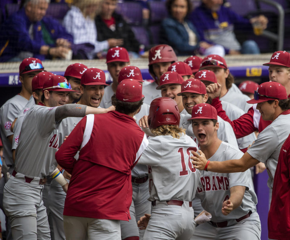 Alabama's Jim Jarvis (10) is mobbed by teammates after hitting the first-inning home run against LSU in an NCAA college baseball game Saturday, April 29, 2023, in Baton Rouge, La. (Michael Johnson/The Advocate via AP)