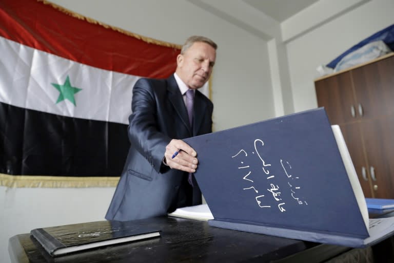 A Syrian civil servant in the Idlib administration checks a register at his temporary base in Hama on March 13, 2017