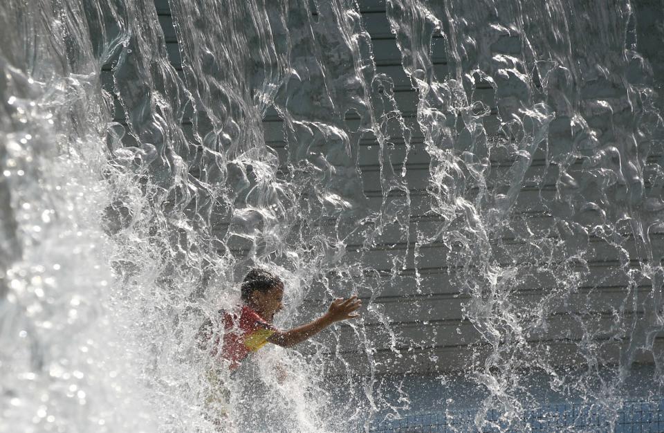 <p>In Kuala Lumpur, der Hauptstadt von Malaysia, kühlt sich ein Junge bei mörderischen Temperaturen im KLCC-Wasserpark ab. (Bild: AP Photo/Daniel Chan) </p>