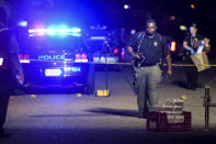 A forensics team member exits the crime scene on Ashton Drive in the Vintage Place neighborhood where several members of law enforcement were shot, one fatally, Wednesday, Oct. 3, 2018, in Florence, S.C. (AP Photo/Sean Rayford)