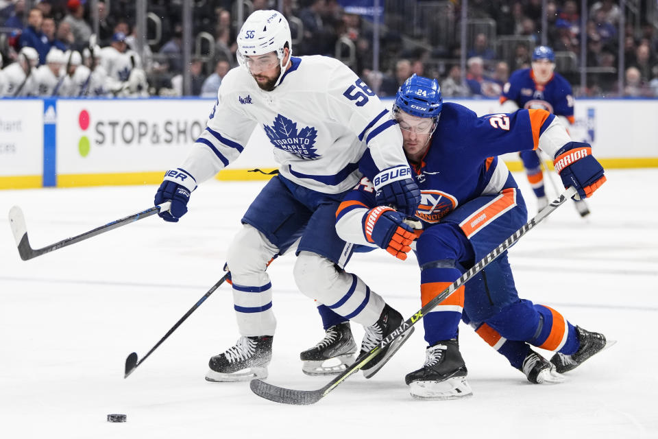 Toronto Maple Leafs' Erik Gustafsson (56) drives past New York Islanders' Scott Mayfield (24) during the first period of an NHL hockey game Tuesday, March 21, 2023, in Elmont, N.Y. (AP Photo/Frank Franklin II)