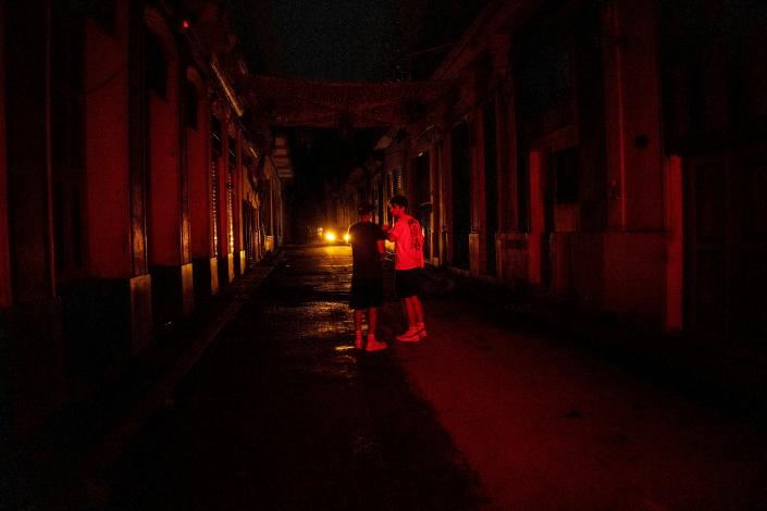 Two tourists talk in the middle of the street during a blackout in Havana, Cuba.