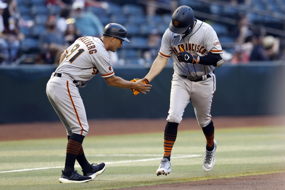 San Francisco Giants' Casey Schmitt is congratulated by third base coach Mark Hallberg (91) after a two-run home run during the second inning of the team's baseball game against the Arizona Diamondbacks, Thursday, May 11, 2023, in Phoenix. (AP Photo/Chris Coduto)