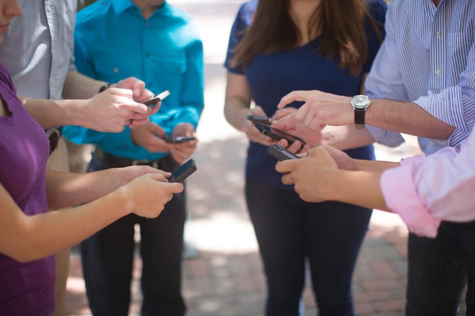 A group of people standing in a circle holding smartphones