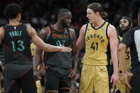 Washington Wizards guard Jordan Poole (13) looks on as teammate forward Eugene Omoruyi (97) exchanges words with Toronto Raptors forward Kelly Olynyk (41) after they had a collision and picked up fouls during first-half NBA basketball game action in Toronto, Sunday, April 7, 2024. (Frank Gunn/The Canadian Press via AP)