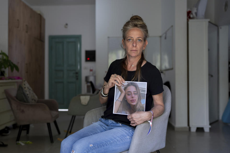 Keren Scharf Schem holds up a portrait of her daughter, 21-year-old Mia Schem, in the family house in Mazor, central Israel, Wednesday, Oct. 25, 2023. Schem, an Israeli and French citizen, was abducted by Hamas militants from the Nova Music Festival near Kibbutz Re'im, Israel, and was taken into Gaza during the group's unprecedented attack on Israel on Oct. 7 that resulted in the killing of 1,400 people and abduction of over 220. (AP Photo/Ohad Zwigenberg)