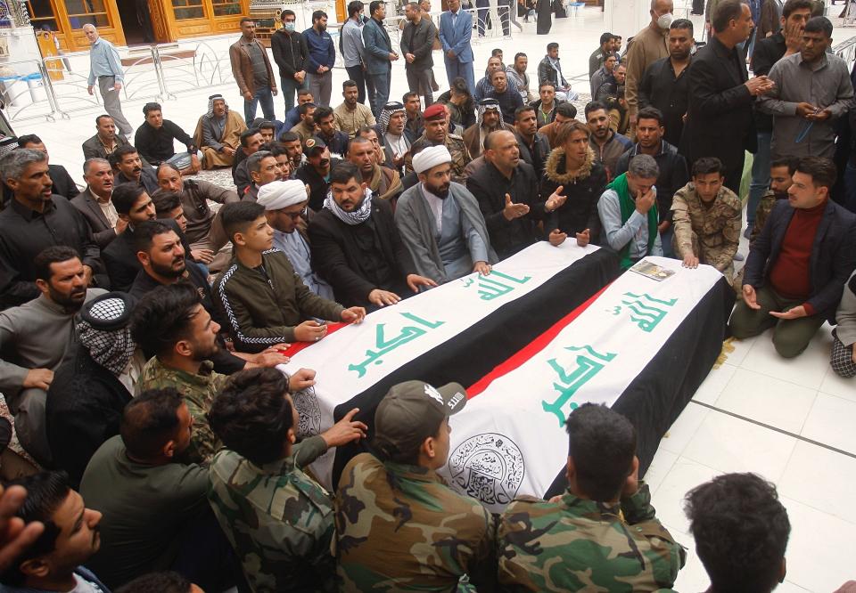 Mourners pray over the flag-draped coffins of two fighters of the Popular Mobilization Forces who were killed during the US attack on against militants in Iraq, during their funeral procession at the Imam Ali shrine in Najaf, Iraq, Saturday, March 14, 2020. The U.S. launched airstrikes on Thursday in Iraq, targeting the Iranian-backed Shiite militia members believed responsible for a rocket attack that killed and wounded American and British troops at a base north of Baghdad. (AP Photo/Anmar Khalil)