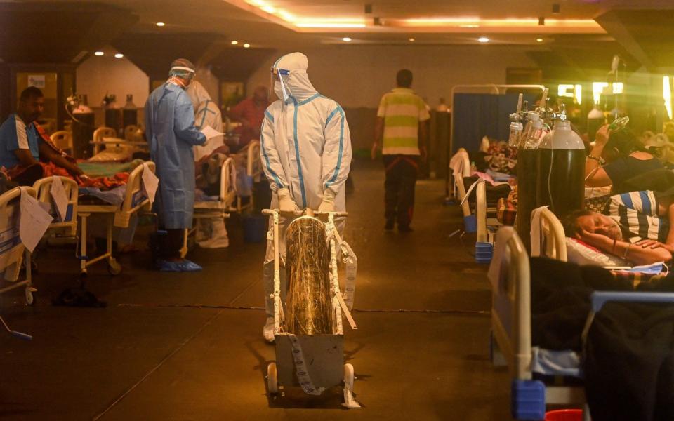 Health workers treat patients inside a converted banquet hall - Prakash Singh/AFP