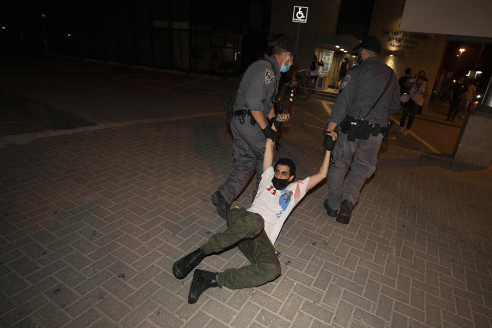 Israeli police officers detain an Israeli protester during a demonstration against lockdown measures that they believe are aimed at curbing protests against Prime Minister Benjamin Netanyahu, in Tel Aviv, Israel, Thursday, Oct. 1, 2020. (AP Photo/Sebastian Scheiner)