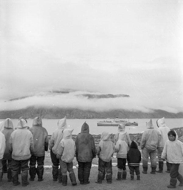 A group of Inuit watching the arrival of the C.D. Howe in Pangnirtung, Nunavut in July, 1951. The ship was used for medical needs and also transported some Inuit south for tuberculosis treatment.