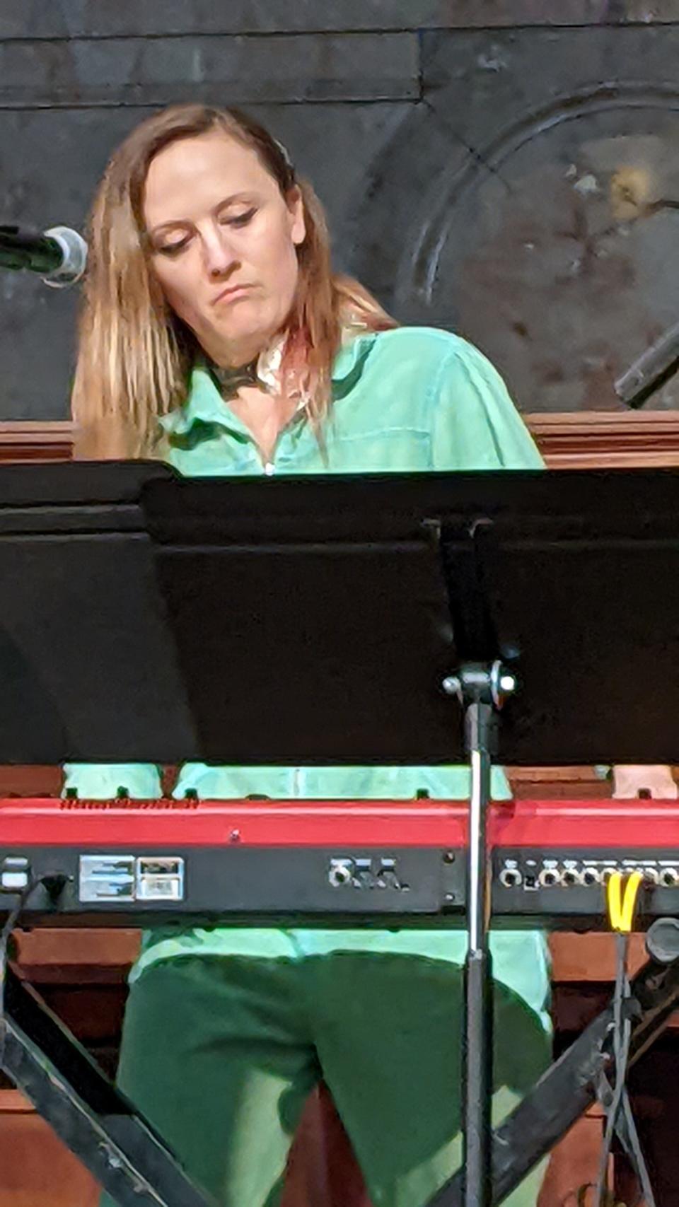 Ellen Reid plays a synthesizer.