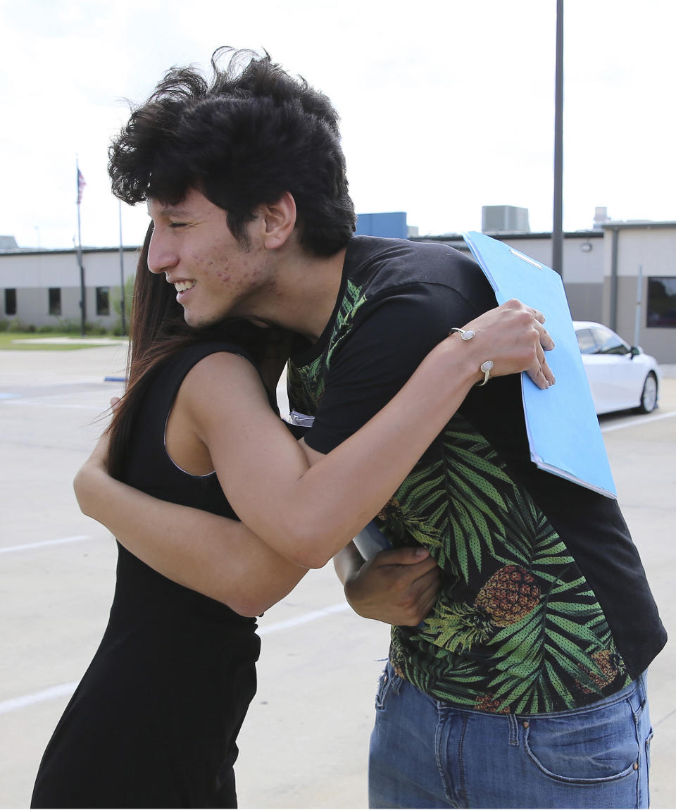 U.S. citizen Francisco Galicia, right, 18, gets a hug from his attorney, Claudia Galan, after his release from the South Texas Detention Facility in Pearsall, Texas, Tuesday, July 23, 2019. Galan arrived on Tuesday to present the necessary paperwork for his release and while talking with media on the scene, ICE officials released Galicia from the facility in the same clothing he wore when he was stopped. Galicia was released from immigration custody after wrongfully being detained for more than three weeks. (Kin Man Hui/The San Antonio Express-News via AP)