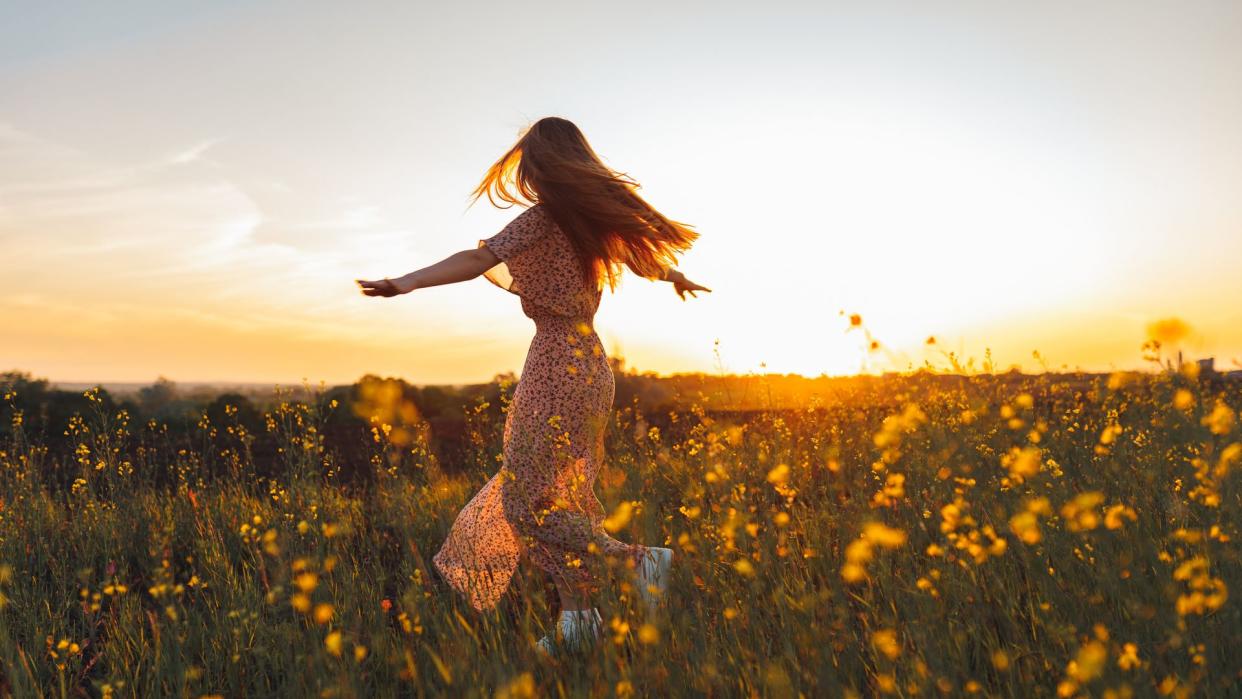 Mujer bailando en un campo de flores