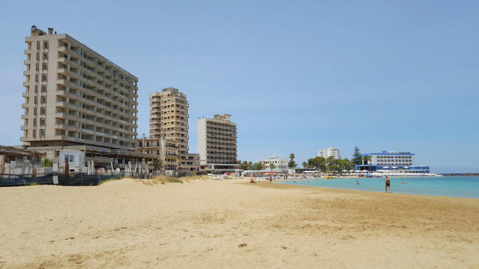 Abandoned hotel buildings stand next to  public beach inside the 'Forbidden Zone' of Varosha.