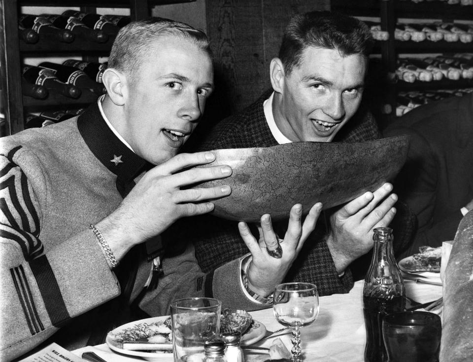 Teammates, Army Half back Pete Dawkins and Billy Cannon of Louisiana State team up As Trenchermen at sports Banquet in New York December 5, 1958. The pair of Associated press All - America backs share a Watermelon. (AP Photo)