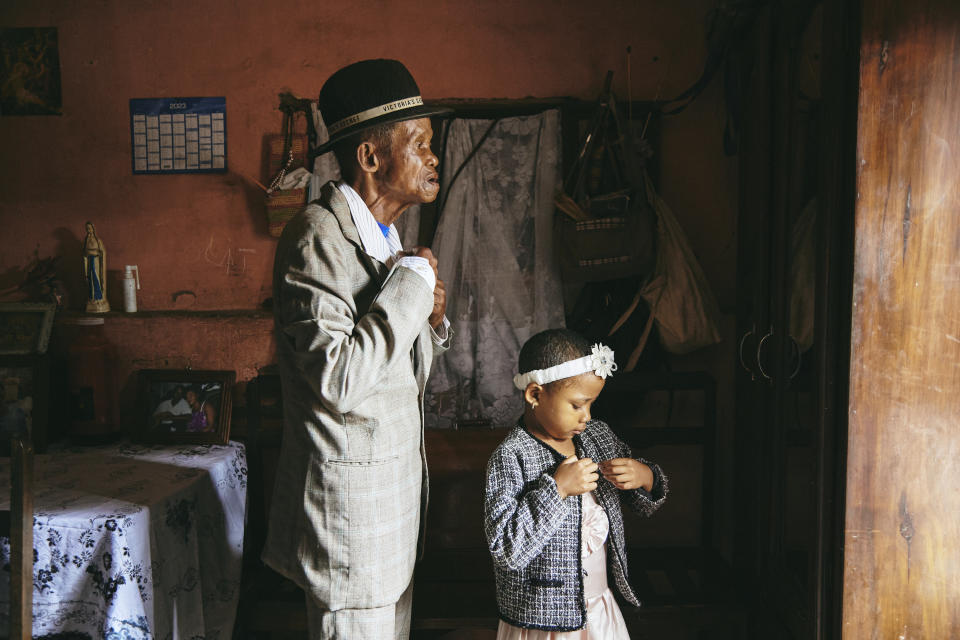 Esta imagen proporcionada por World Press Photo y tomada por Lee-Ann Olwage para GEO forma parte de una serie llamada Valim-babena que ganó el premio World Press a Historia del Año, y muestra a Dada Paul Rakotazandriny, de 91 años, que tiene demencia, y a su nieta, Odliatemix Rafaraniriana, de 5 años, prepararse para la iglesia el domingo por la mañana en su casa de Antananarivo, Madagascar, el 12 de marzo de 2023. (Lee-Ann Olwage/Geo/World Press Photo via AP)