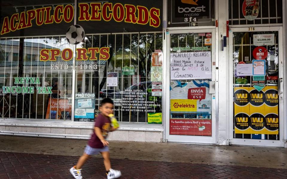 A boy walks past closed businesses on Washington Avenue in Homestead, Florida on June 1. Local Businesses closed their doors for the day to protest a new state law that targets migrants.