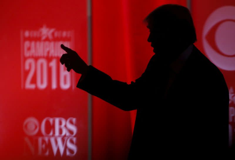FILE PHOTO: Republican U.S. presidential candidate businessman Donald Trump speaks to someone offstage during a commercial break at the Republican U.S. presidential candidates debate sponsored by CBS News and the Republican National Committee in Greenville