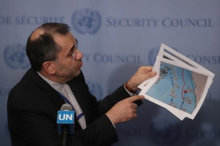 Iranian Ambassador to the United Nations Majid Takht-Ravanchi shows maps of airspace to the media outside Security Council chambers at the U.N. headquarters in New York