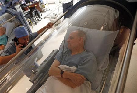 Doctor Andy Chiou (L) speaks to patient Carl Dolson in a hyperbaric chamber in Peoria, Illinois, November 26, 2013. REUTERS/Jim Young