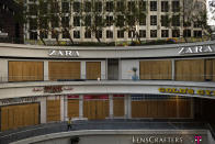 A woman walks past shops covered in plywood panels to protect the properties against potential vandalism and looting Wednesday, June 3, 2020, in downtown Los Angeles, as protests continue over the death of George Floyd on May 25 in Minneapolis. Los Angeles County pushed back the start of its curfew from 6 p.m. to 9 p.m., a help to newly reopened restaurants and retail stores that were shut down for weeks by anti-coronavirus orders. (AP Photo/Jae C. Hong)