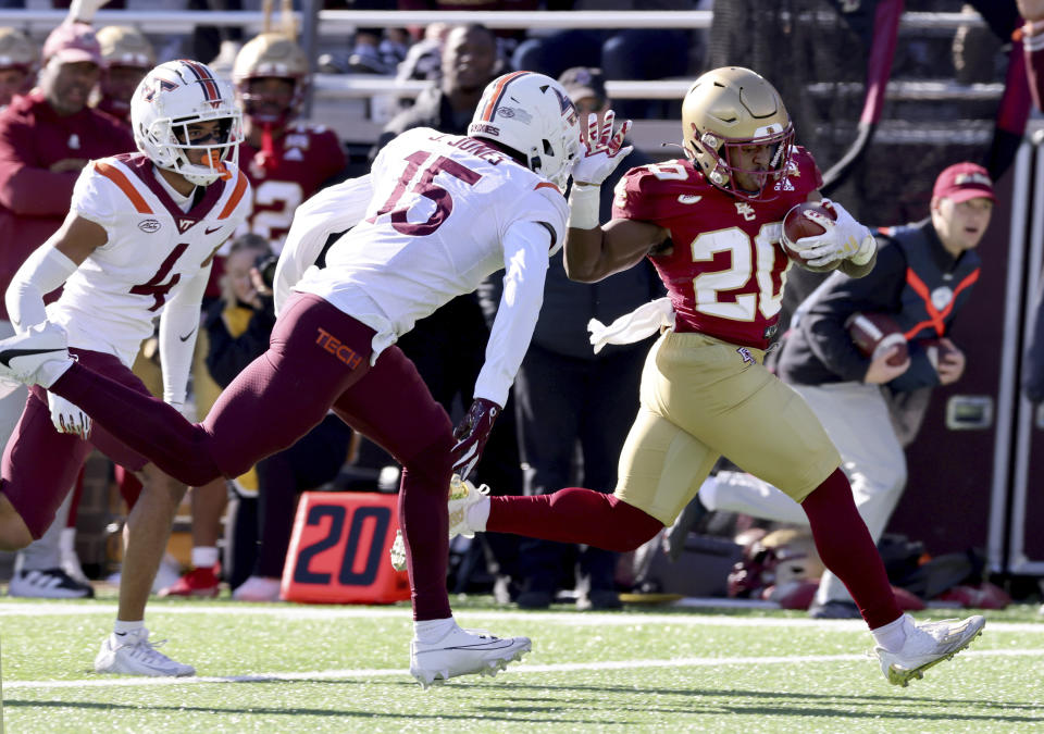 Boston College running back Alex Broome (20) fends off Virginia Tech safety Jaylen Jones (15) as he runs towards the end zone during the first half of an NCAA college football game Saturday, Nov. 11, 2023 in Boston. (AP Photo/Mark Stockwell)