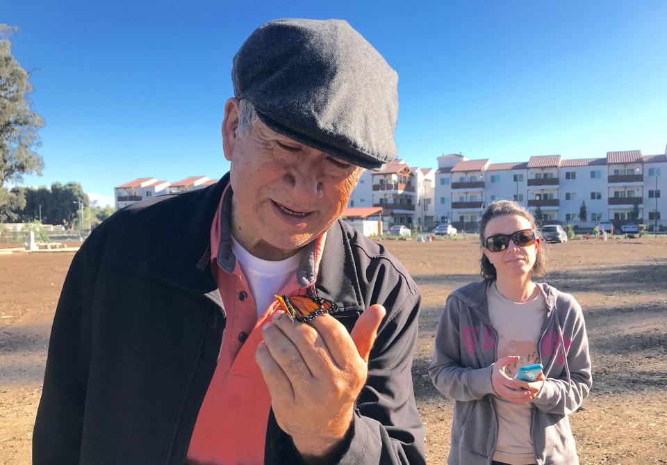 Robert Garcia, owner of the historic cemetery along Pleasant Valley Road, looks at a monarch butterfly before it's released into the wild.