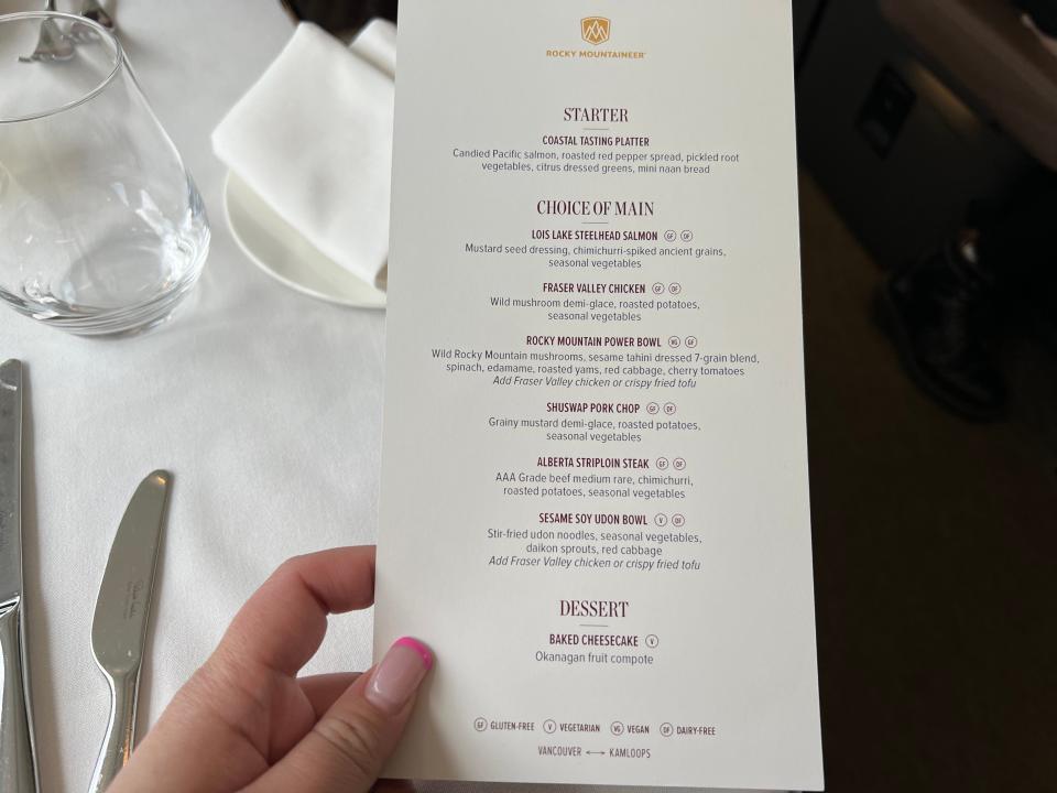 The writer holds a lunch menu on the Rocky Mountaineer train