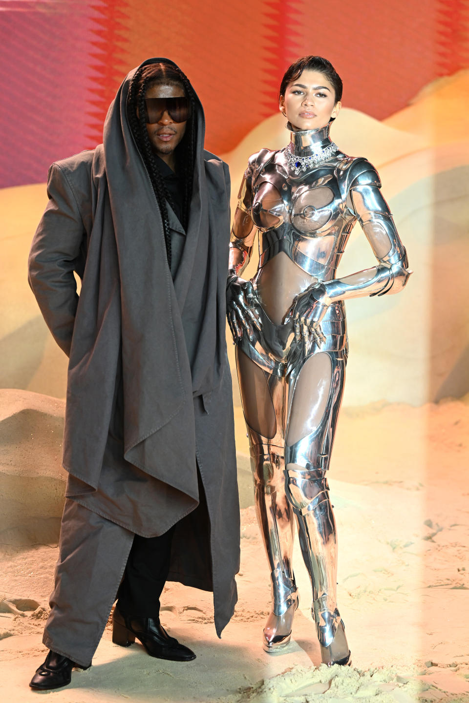 Zendaya in a metallic robot-inspired outfit and Law in a long coat with a hood
