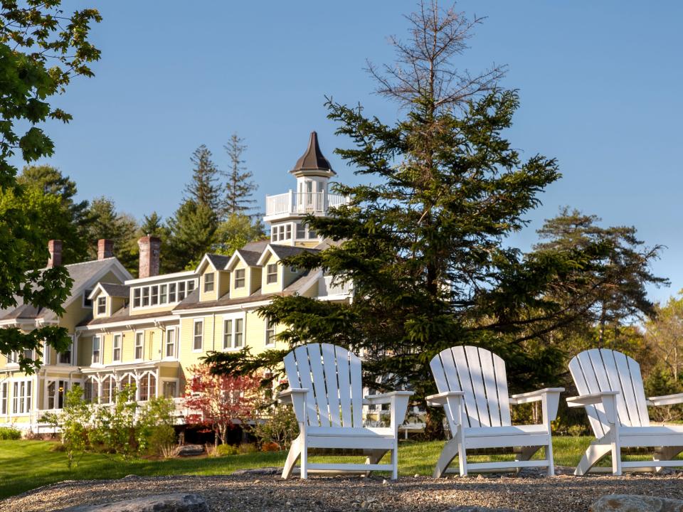 Adirondack chairs in backyard garden next to large victorian house in summer, Captain Nickels Inn, near Belfast, Maine, USA
