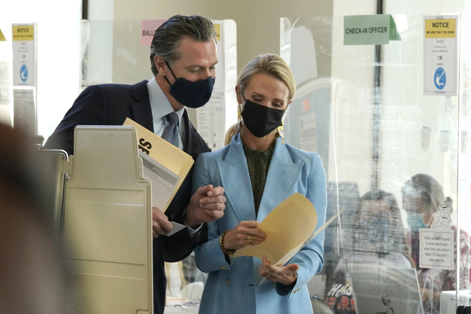 California Gov. Gavin Newsom, looks over to see how his wife First Partner Jennifer Siebel Newsom voted, when they cast their ballots at a voting center in Sacramento, Calif., Friday, Sept. 10, 2021. The last day to vote in the recall election is Tuesday, Sept. 14. A majority of voters must mark "no" on the recall to keep Newsom in office. (AP Photo/Rich Pedroncelli)