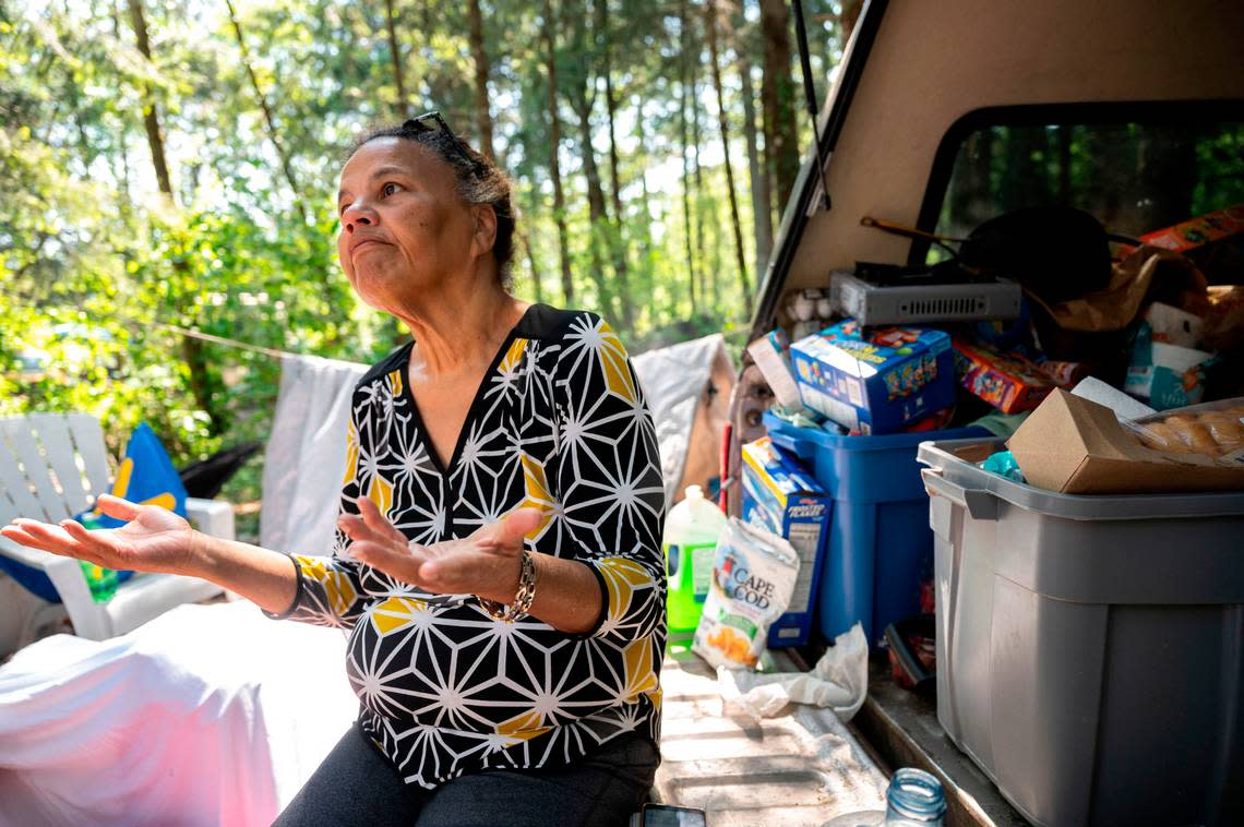 Bouviea Aaron, 65, sits on the back of her truck, where she also sleeps, while talking about some of the issues that persist at the homeless camp she lives in on the 9700 block of Steele Street South on Thursday, May 25, 2023, in Tacoma. Known as “The Jungle,” the camp is home to roughly 30-40 people at any given time. Aaron has lived there for the past three months while she attempts to sort out a permanent living situation.