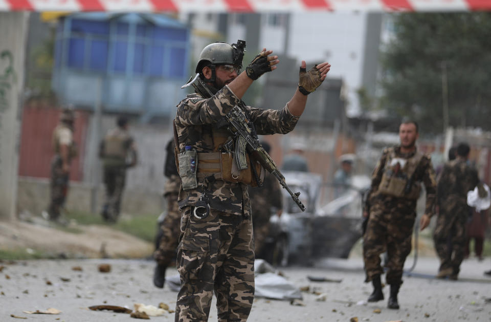 Security personnel inspect a damaged vehicle which was firing rockets in Kabul, Afghanistan, Tuesday, July 20, 2021. At least three rockets hit near the presidential palace on Tuesday shortly before Afghan President Ashraf Ghani was to give an address to mark the Muslim holiday of Eid-a-Adha. (AP Photo/Rahmat Gul)