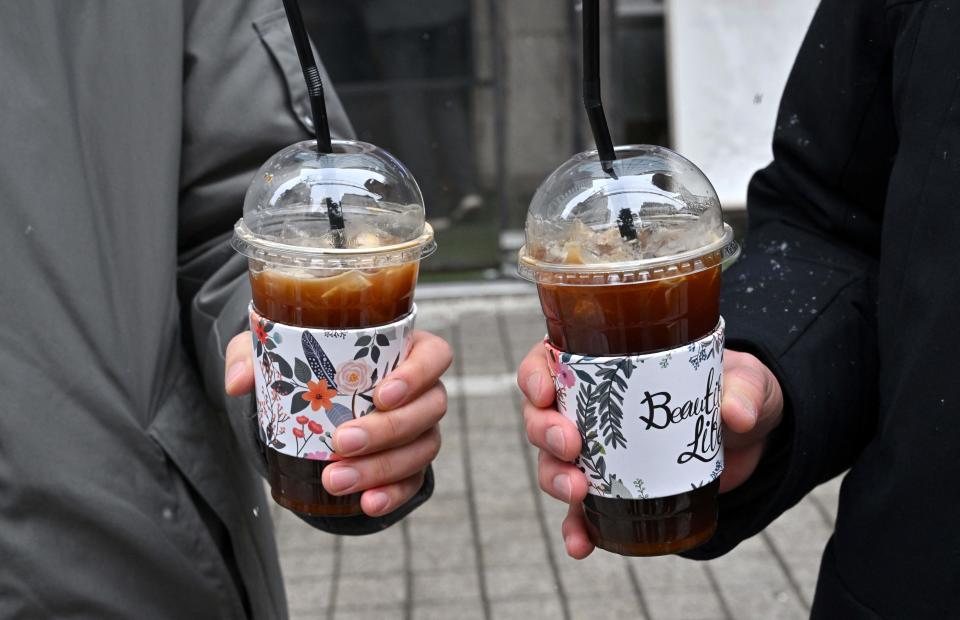 商界成本大增，南韓政府聽民意無限期押後「走塑令」，圖為南韓民眾手持外賣咖啡。 (Photo by Jung Yeon-je / AFP) (Photo by JUNG YEON-JE/AFP via Getty Images)