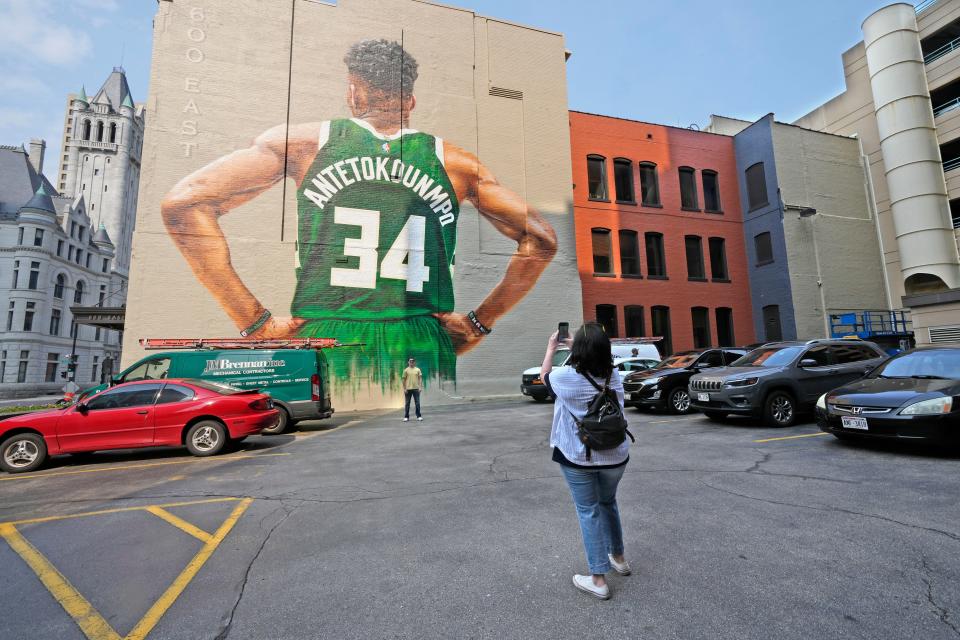 Joseph Angeli of Vulcan, Michigan, has his picture taken by his mother in front of the Giannis Antetokounmpo mural in downtown Milwaukee during the 2022 playoffs.