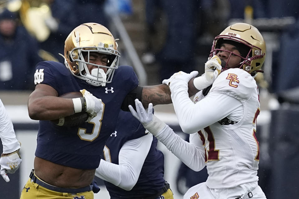 Notre Dame running back Logan Diggs is chased by Boston College defensive back Josh DeBerry during the first half of an NCAA college football game, Saturday, Nov. 19, 2022, in South Bend, Ind. (AP Photo/Darron Cummings)