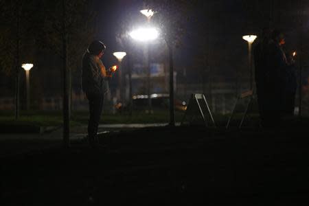 A woman stands by herself during a candlelight vigil for teacher Colleen Ritzer outside the high school where she taught in Danvers, Massachusetts October 23, 2013. REUTERS/Brian Snyder