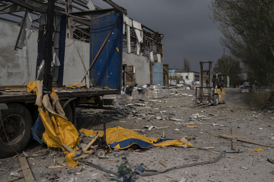 The body of a man is covered by a tarp from a damaged truck following a Russian bombing of a factory in Kramatorsk, in eastern Ukraine, on Tuesday, April 19, 2022. Russian forces attacked along a broad front in eastern Ukraine on Tuesday as part of a full-scale ground offensive to take control of the country's eastern industrial heartland in what Ukrainian officials called a "new phase of the war." (AP Photo/Petros Giannakouris)