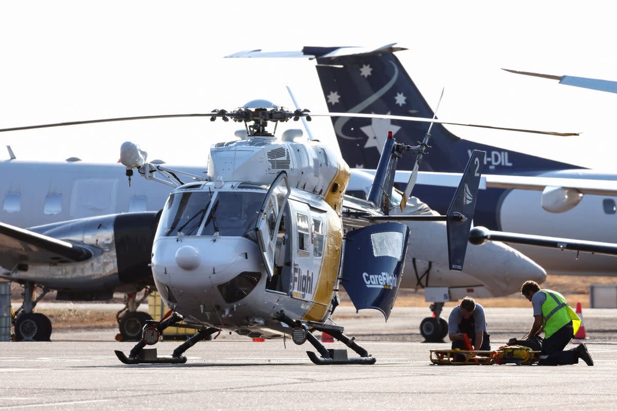A Care Flight helicopter is seen on the tarmac of the Darwin International Airport in Darwin as rescue work is in progress to transport those injured in the US Osprey military aircraft crash at a remote island north of Australia’s mainland (AFP via Getty Images)