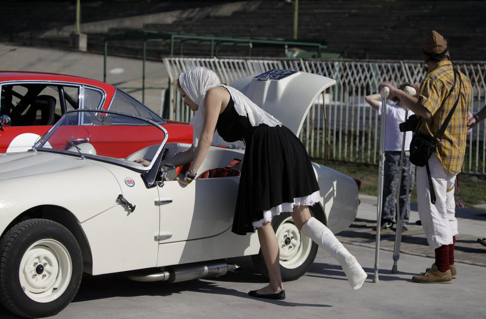 A young woman driver prepares her car for the show near the oval track of a velodrome during an old timer car and motorcycle show in Budapest on May 1, 2012. The event brought life again into the 412 meter long Millennial Velodrome of Budapest, which was built in 1896 and is one of the oldest arenas for track cycling in Europe.  AFP PHOTO / PETER KOHALMIPETER KOHALMI/AFP/GettyImages