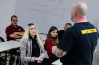 Former Sandy Hook teacher Kaitlin Roig (2nd L) listens to Armoured One CEO Tom Czyz (R) as he speaks to teachers and staff members during an active shooter training at James I. O'Neill High School in Highland Falls, New York, U.S., December 12, 2017. REUTERS/Eduardo Munoz